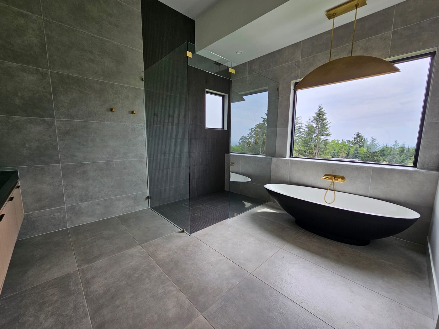 A sculptural tub on large-format tile by Artemidas Renovation, Loganville